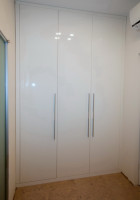 Встроенный распашной шкаф с фасадами из МДФ в высокоглянцевой эмали выкрашенный по каталогу RAL  в цвете  9003.